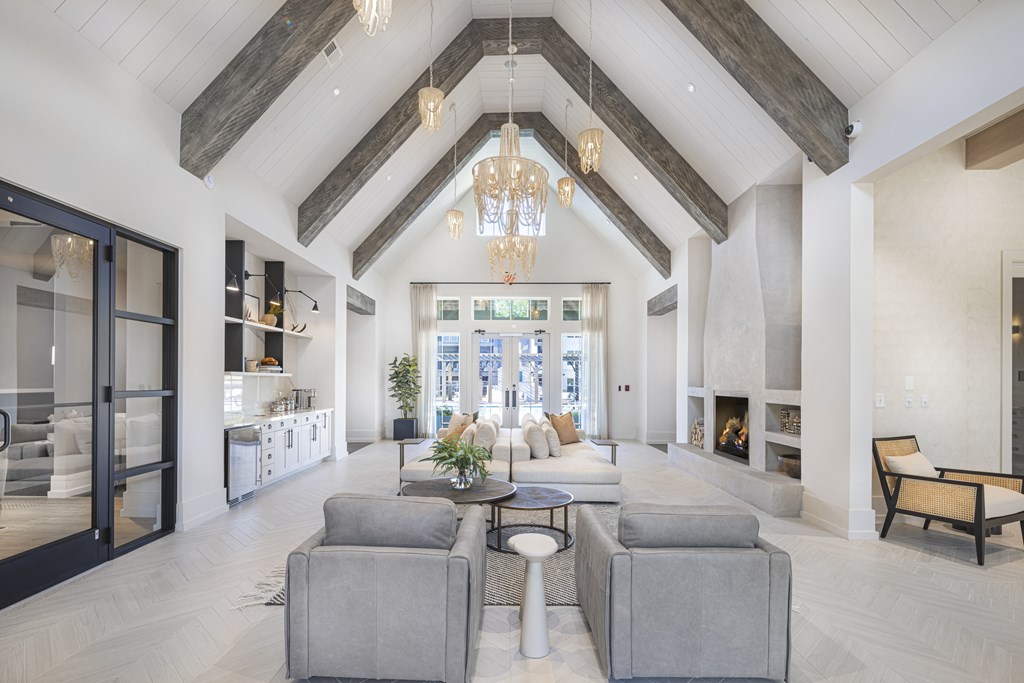 A large, open-concept living room with a high ceiling and a fireplace at Folksong Apartments, Flowery Branch, Georgia