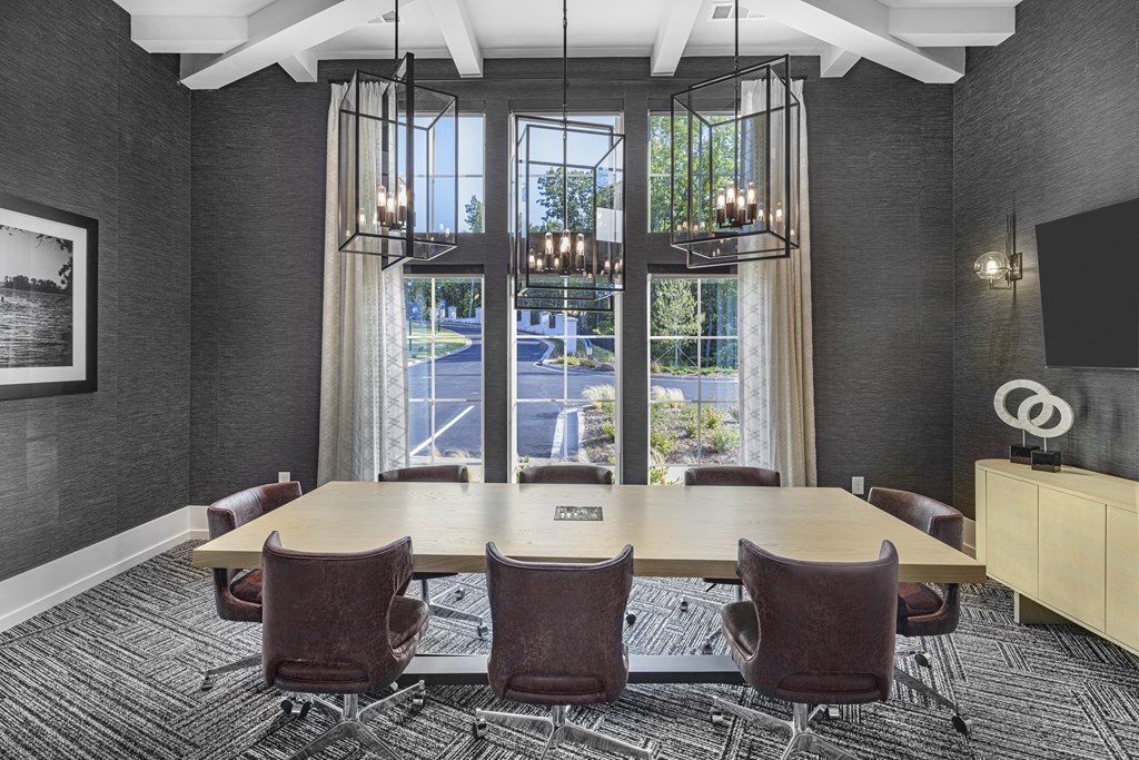 A conference room with a long table and chairs at Folksong Apartments, Flowery Branch, GA 30542