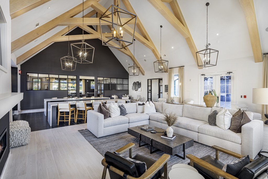 A modern living room with a high ceiling and wooden beams at Folksong Apartments, Flowery Branch, 30542