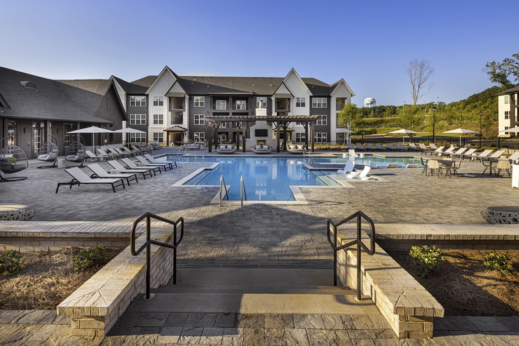 A large building with a pool in front at Folksong Apartments, Flowery Branch, GA 30542