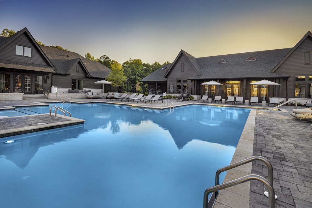 A large swimming pool in front of a house with a deck and lounge chairs at Folksong Apartments, Flowery Branch