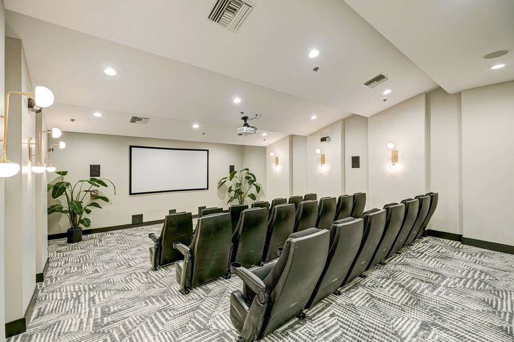 a conference room with a projector screen and chairs