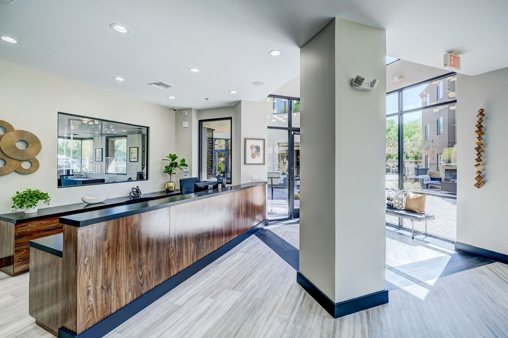 a large lobby with a reception desk and glass doors