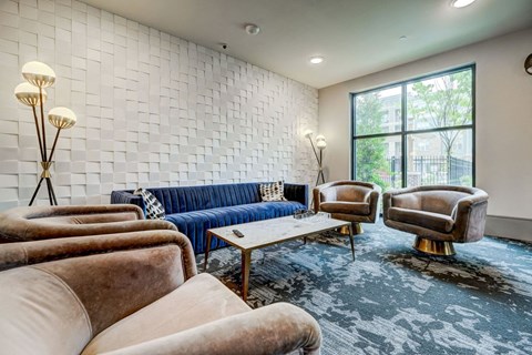 A living room with a blue couch and two chairs.