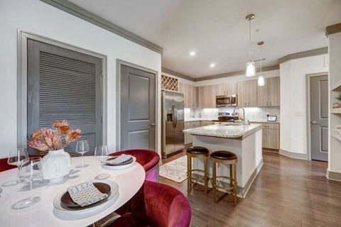A modern kitchen with a dining table set for two.