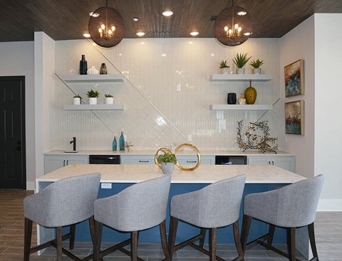 a kitchen with a marble counter top and four chairs