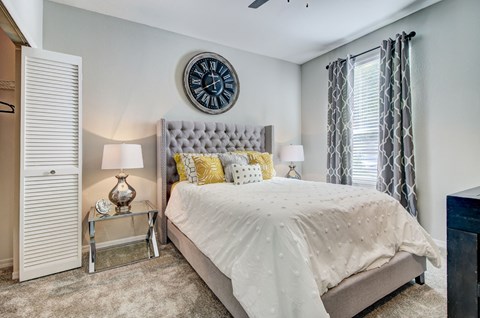 Large bedroom with neutral color scheme with a closet and large windows at Tuscany Bay Apartments, Tampa, Florida