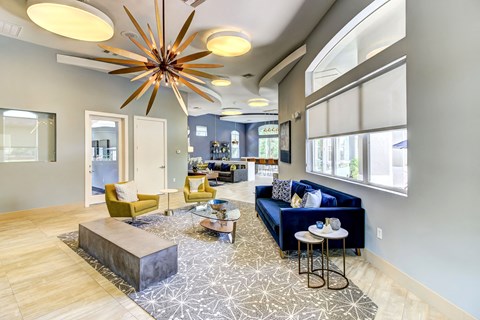 A modern living room with a yellow chair and a blue sofa.