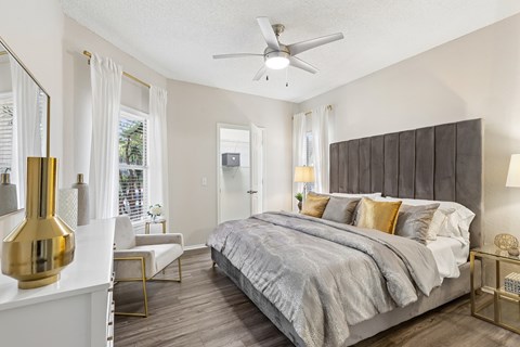 A bedroom with a large bed and a ceiling fan.