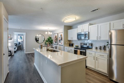 an open kitchen with stainless steel appliances and white cabinets