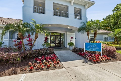 A white building with a sign that says "Clubhouse and Pool".
