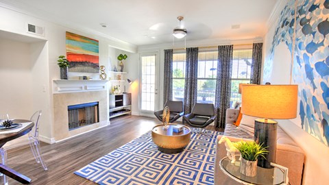 a living room with a fireplace and a blue and white rug