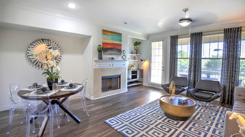 a living room with a fireplace and a table and chairs