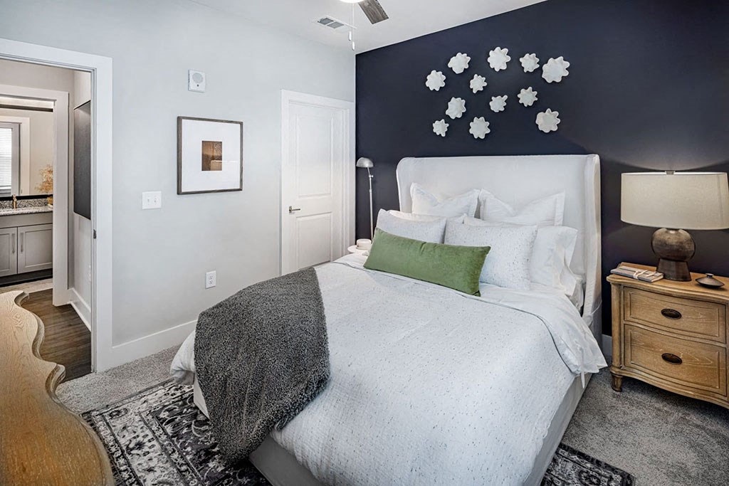 A bedroom with a white bed and a green pillow.