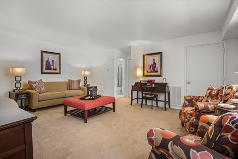 A living room with a couch, a coffee table, and a painting on the wall.