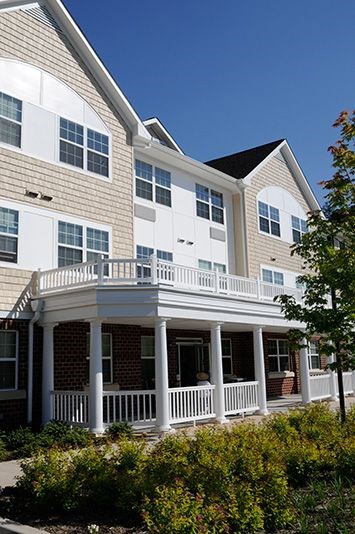 A house with a white porch and a black roof.