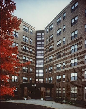 A tall brick building with a black awning in front.