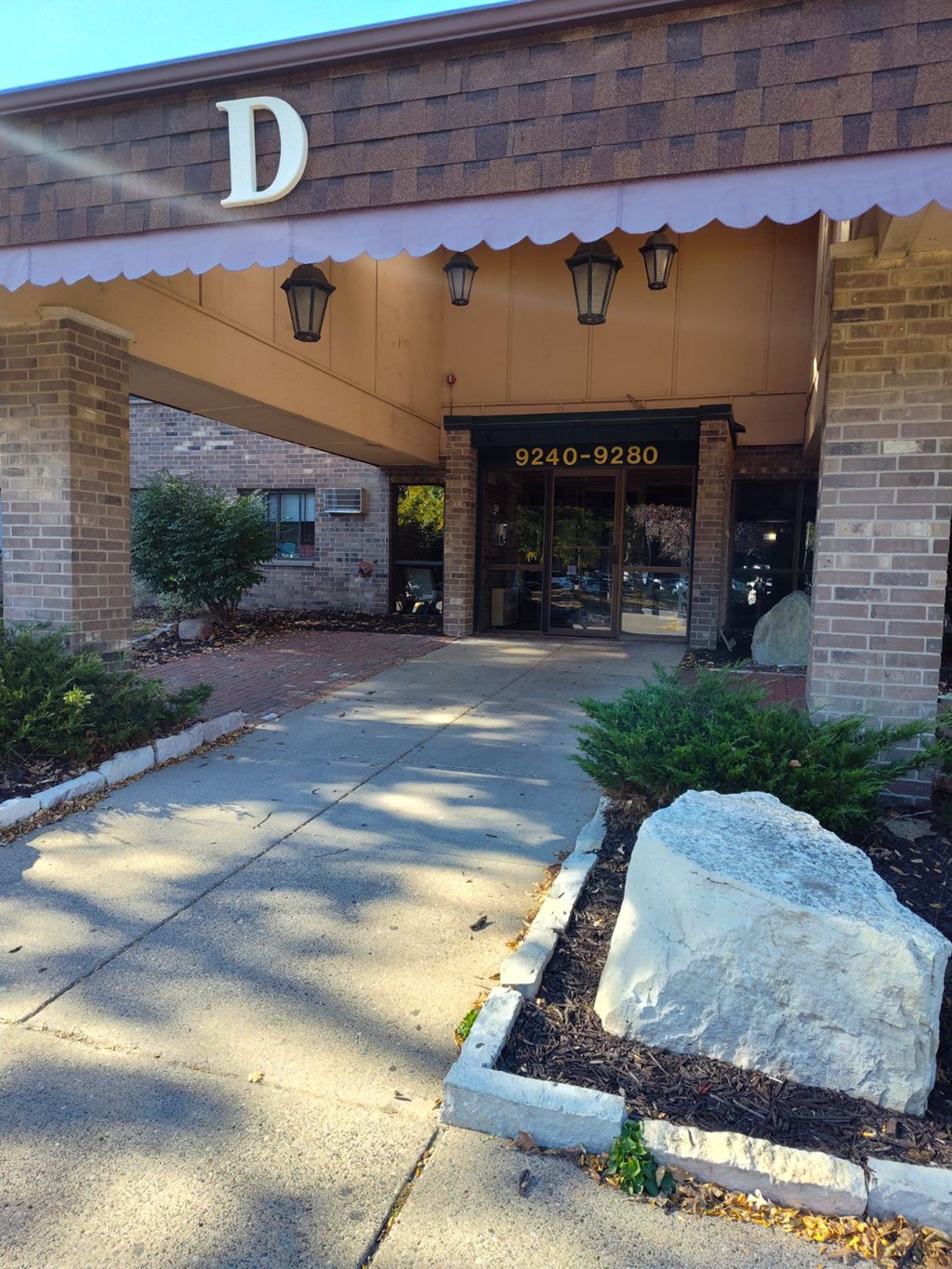 the front entrance of a building with a white awning