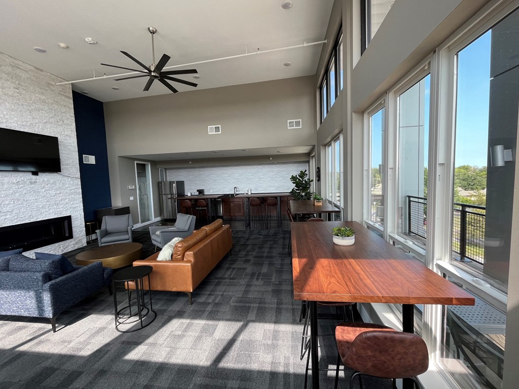 a room with couches chairs and a table and a large window