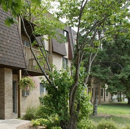 a building with a balcony and trees in front of it