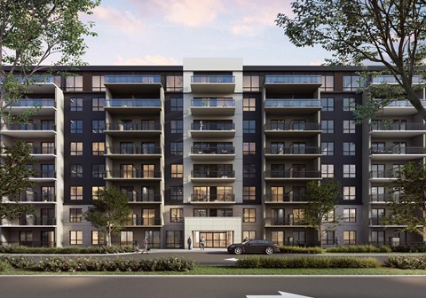 A modern apartment building with a car parked in front.