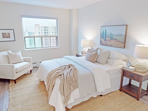 A bedroom with a large bed and a painting on the wall.