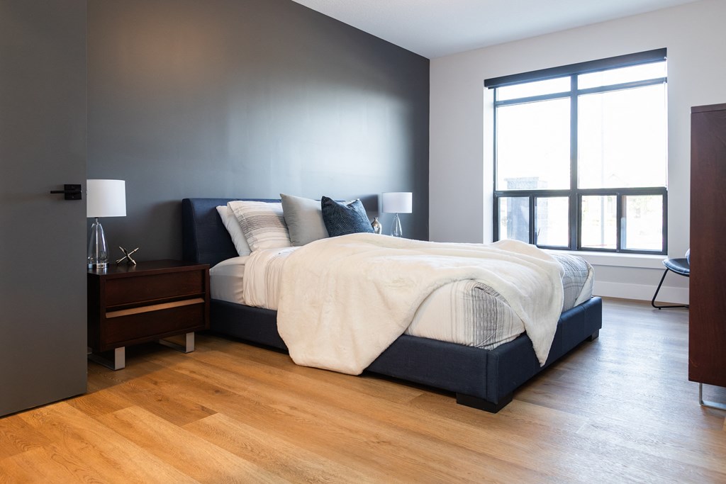 a bedroom with a bed and a wood floor