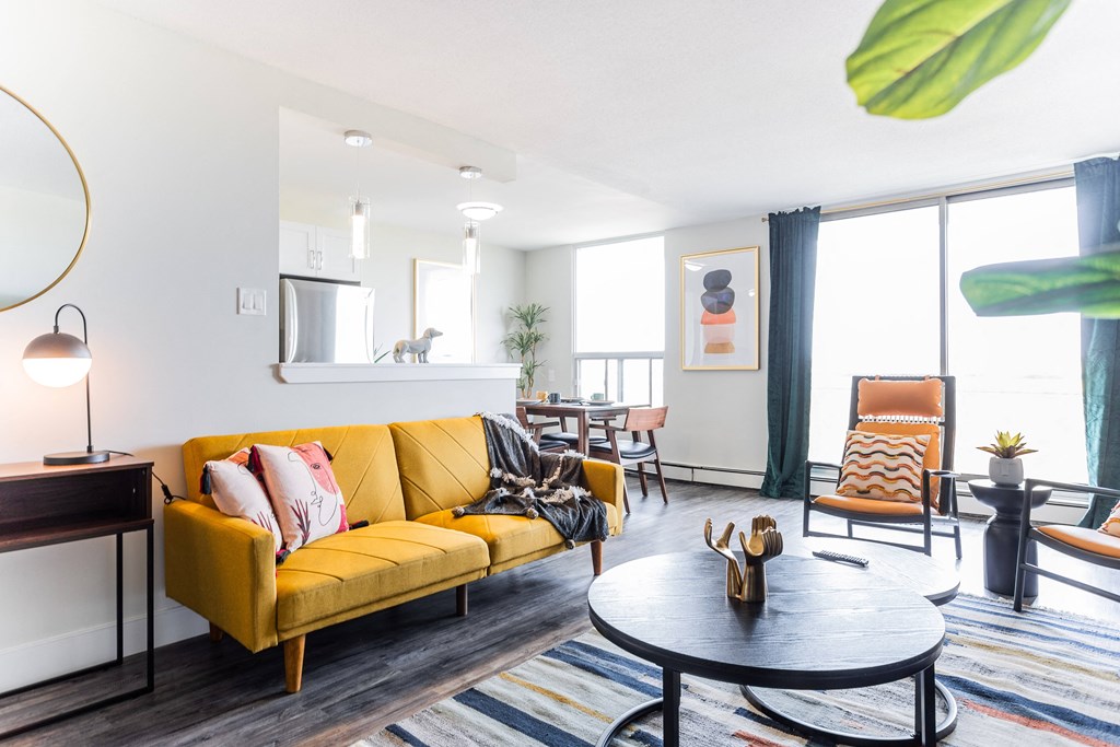 a living room with a yellow couch and a table