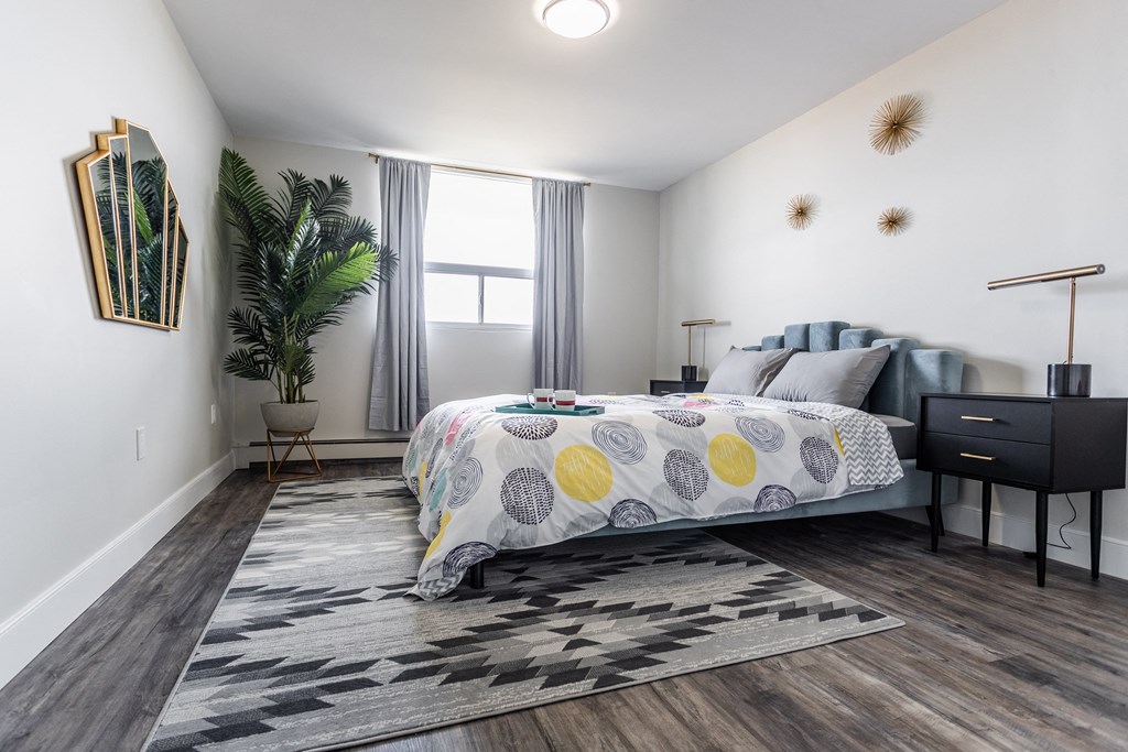 a bedroom with a bed and a dresser and a window