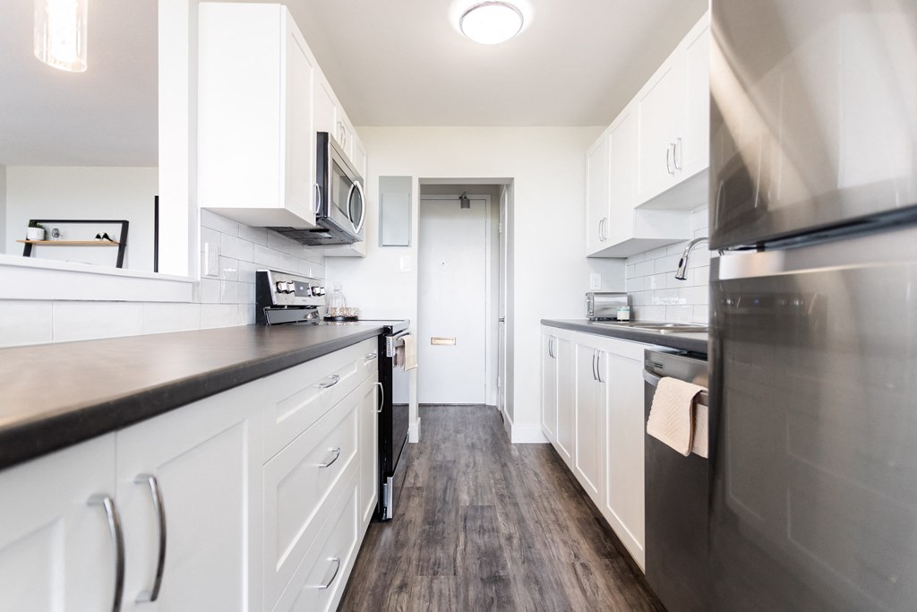 a kitchen with white cabinets and stainless steel appliances