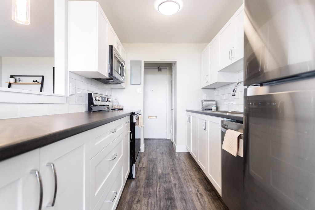 a kitchen with white cabinets and stainless steel appliances