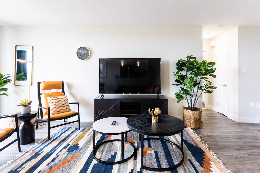 a living room with a tv and a table and chairs