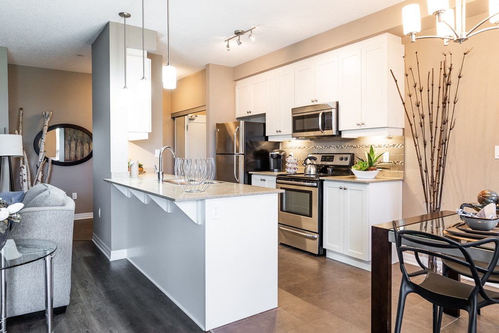 a kitchen with white cabinets and stainless steel appliances