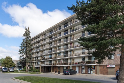 a large apartment building with balconies and cars parked outside