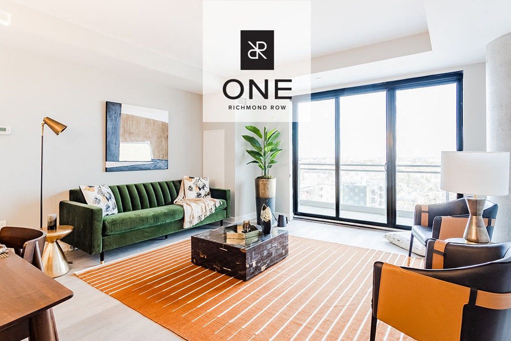 a living room with a green couch and a large window