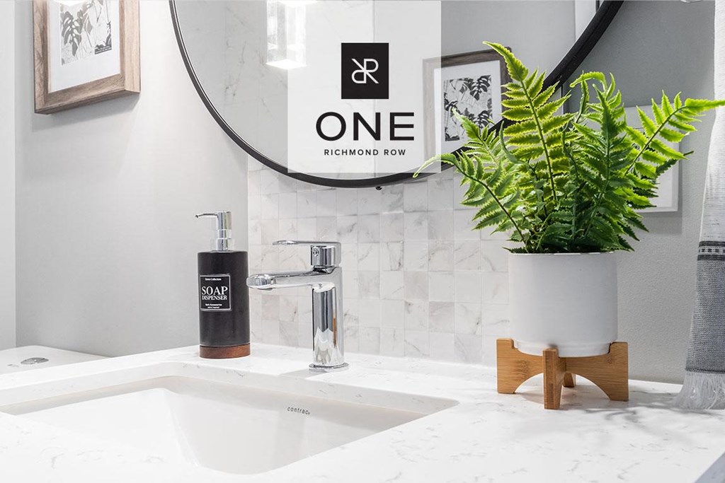 a white bathroom with a sink and a plant