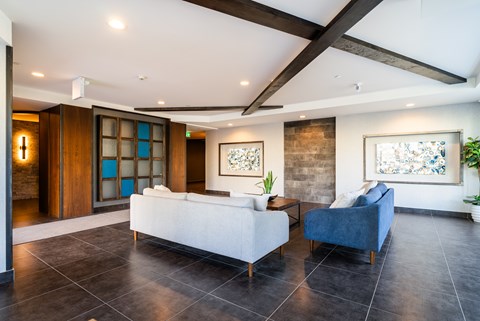 A modern living room with a white couch and a blue chair.