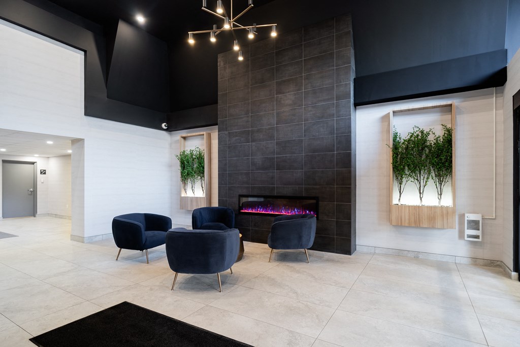 a lobby with two blue chairs and a fireplace