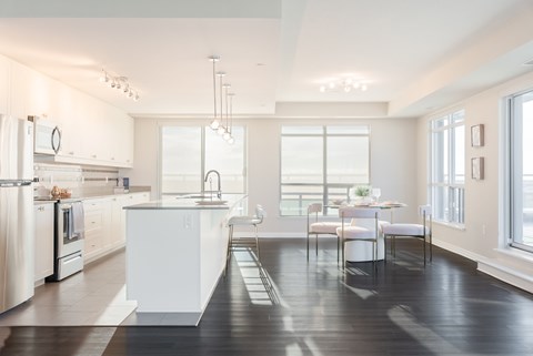 A modern kitchen with white appliances and a dining table.