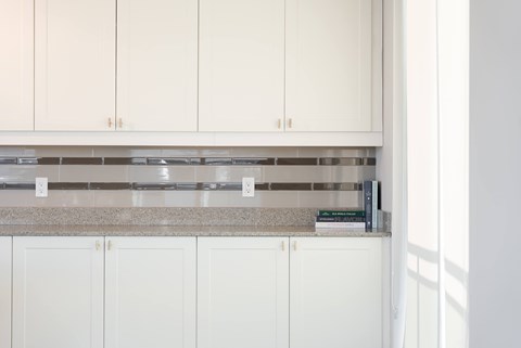 A kitchen with white cabinets and a granite countertop.