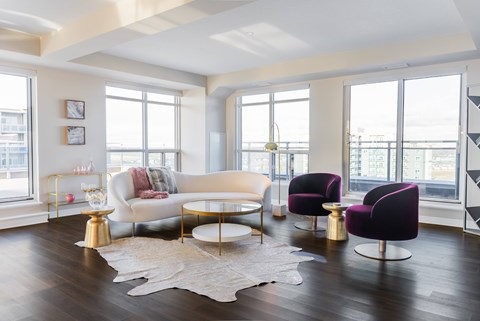 A living room with a white couch and purple chairs.