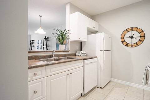 a kitchen with white cabinets and a sink and a refrigerator