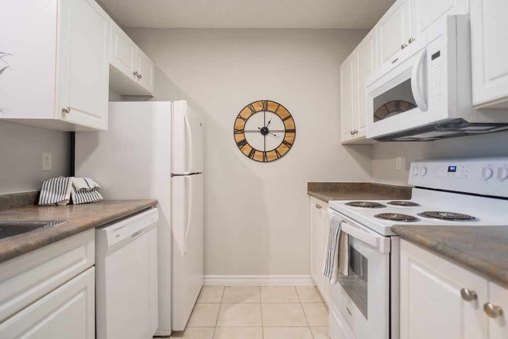 a kitchen with white appliances and a clock on the wall