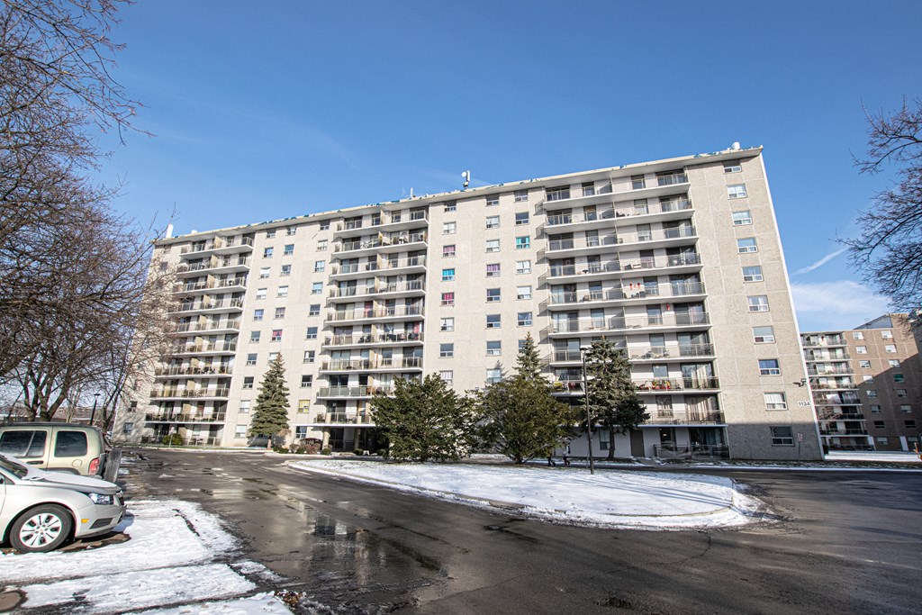 a large apartment building on a city street with snow
