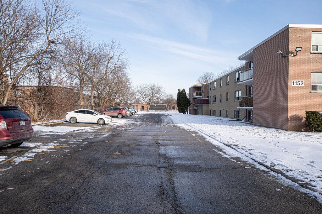 a street with snow and a building on the side of it