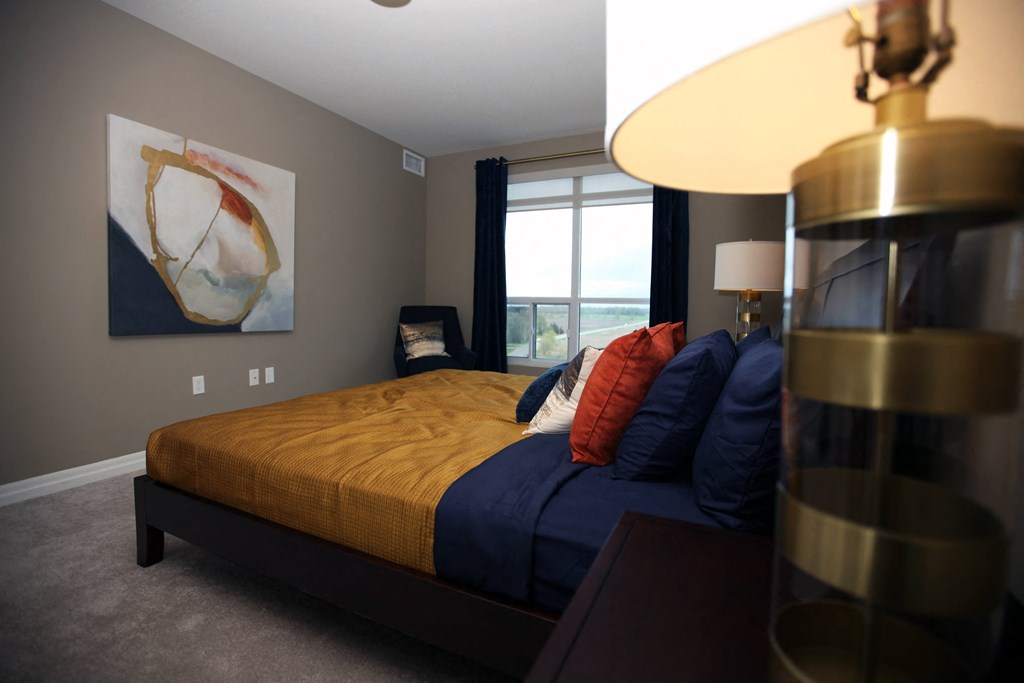 a bedroom with a bed and a lamp and a window