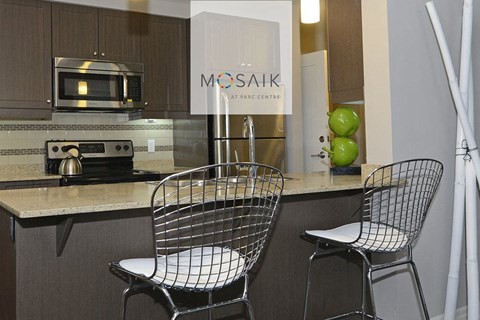 a kitchen with a counter and two chairs