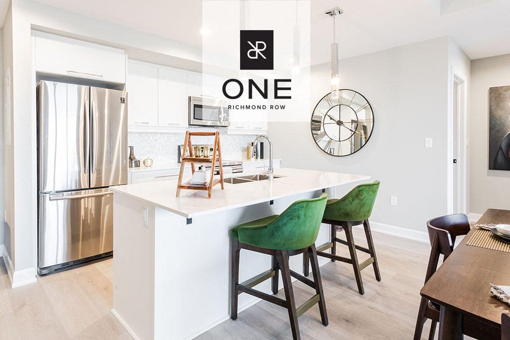 a kitchen with an island and a stainless steel refrigerator