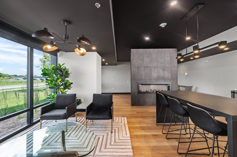 A modern living room with a fireplace and a long table.