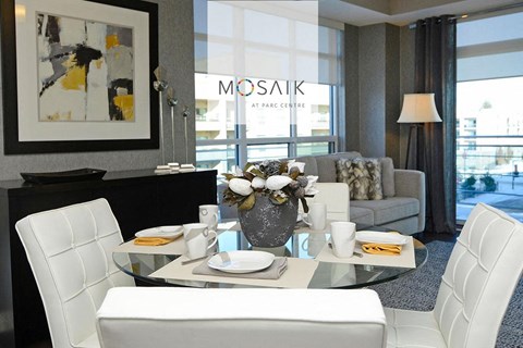 a living room with white chairs and a glass table